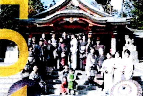 神社の境内前にて和傘を広げて並ぶ参加者の記念写真